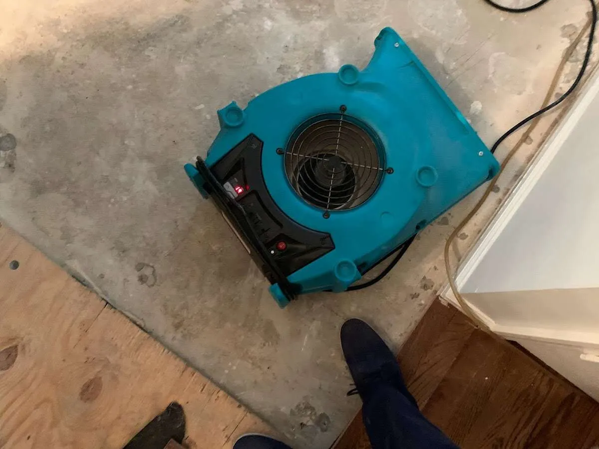 Air mover drying subfloor during Commercial Water Damage Restoration in Houghton